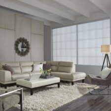 Beautiful, bright, modern living room with motorized window treatments and a large window.