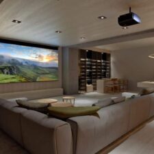 Modern home theater/media room with large sectional, screen and projector, pool table, and wine bar.